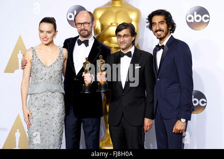Filmmakers James Gay-Rees (2nd from L) and Asif Kapadia (2nd from R), winners of the Best Documentary Feature award for 'Amy', pose with actress Daisy Ridley and actor Dev Patel in the press room during the 88th Annual Academy Awards at Loews Hollywood Hotel on February 28, 2016 in Hollywood, California. Stock Photo