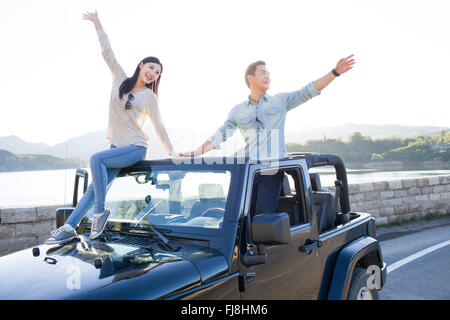 Young Chinese couple having fun in a jeep Stock Photo