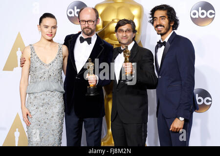 Filmmakers James Gay-Rees (2nd from L) and Asif Kapadia (2nd from R), winners of the Best Documentary Feature award for 'Amy', pose with actress Daisy Ridley and actor Dev Patel in the press room during the 88th Annual Academy Awards at Loews Hollywood Hotel on February 28, 2016 in Hollywood, California. Stock Photo