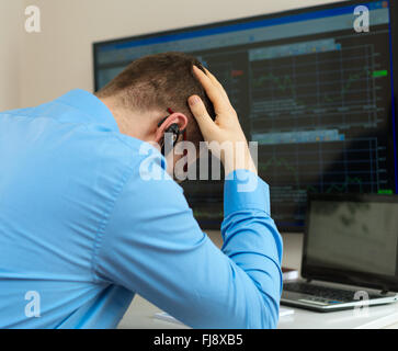 Upset stock trader in front of computer. Stock Photo