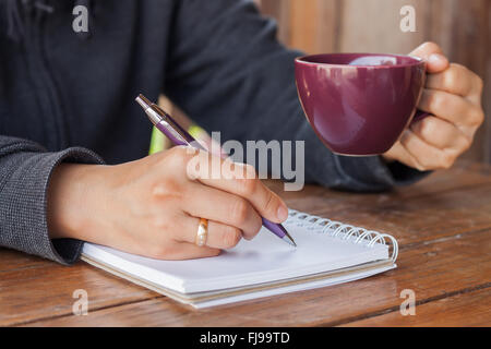 Woman hand with pen writing on notebook, stock photo Stock Photo