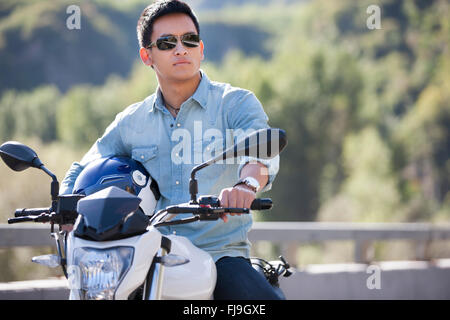 Young Chinese man riding motorcycle Stock Photo