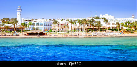 SHARM EL SHEIKH, EGYPT - FEBRUARY 25, 2014: Coastal lighthouse and hotel on the beach, a luxury vacation for tourists in Red sea Stock Photo