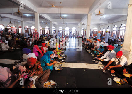 Devotees eating in Guru ka Langar, Golden Temple, Amritsar, Punjab, India, Asia Stock Photo