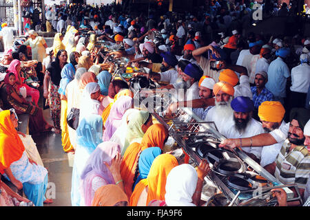 Devotees in guru ka langar, community kitchen of gurdwara, golden temple, amritsar, punjab, india, asia, asian, indian Stock Photo