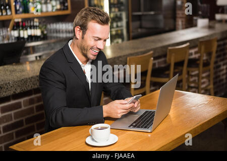 Thoughtful man using laptop and smartphone Stock Photo