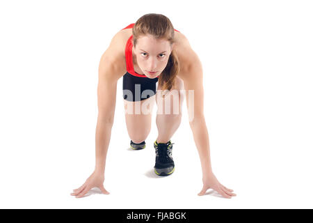 Young athletic woman in crouched starting position ready to start race. Isolated on white background. Stock Photo