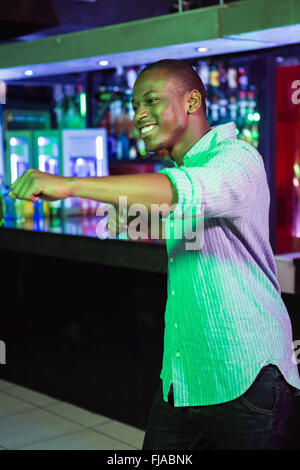 Happy man dancing in front of bar counter Stock Photo