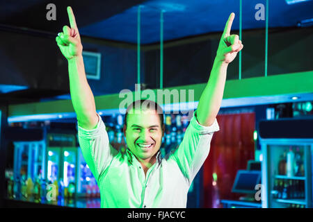 Happy man dancing in front of bar counter Stock Photo