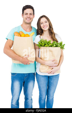 Happy couple carrying grocery bags Stock Photo
