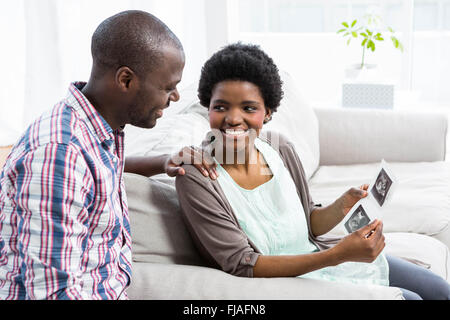 Pregnant couple looking at ultrasound scan Stock Photo