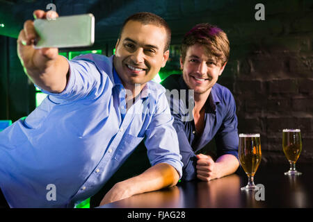 Two men taking a selfie on phone at bar counter Stock Photo