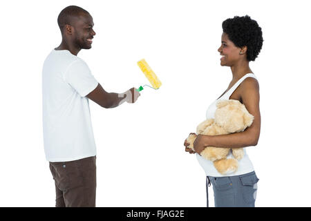 Pregnant couple painting with paint roller Stock Photo