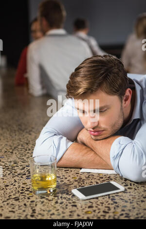 Tired man leaning on counter Stock Photo