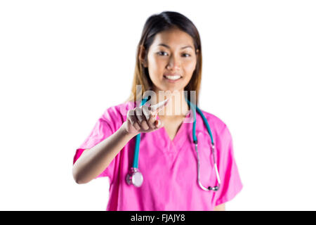 Asian nurse with stethoscope pointing in front of her Stock Photo