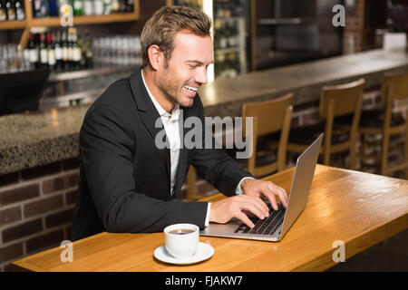 Handsome man using laptop and having a coffee Stock Photo