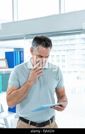 Thoughtful man using digital tablet Stock Photo