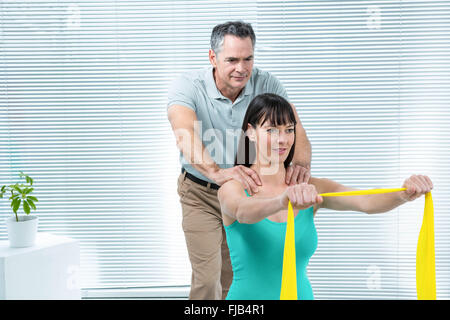 Physiotherapist guiding pregnant woman with exercise Stock Photo