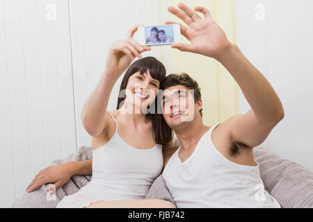 Couple lying on sofa and taking a selfie Stock Photo