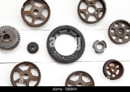 Interlocking industrial  cogwheels on white wooden background Stock Photo