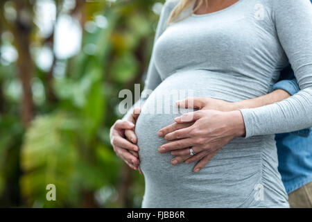 Man holding pregnant womans stomach Stock Photo