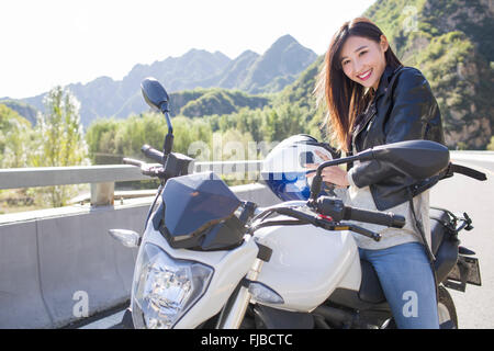 Young Chinese woman riding motorcycle Stock Photo