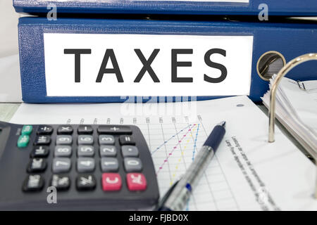 Tax file folder on the table with calculator and pen. Stock Photo