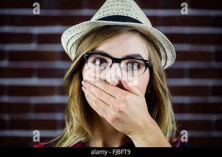 Pretty blonde woman covering her mouth with her hand Stock Photo