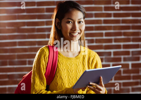 Smiling asian female student using tablet Stock Photo