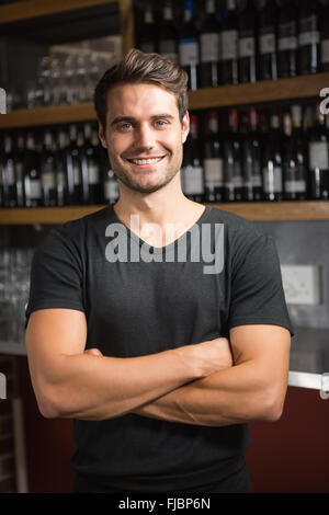 Handsome bar tender standing behind his counter Stock Photo