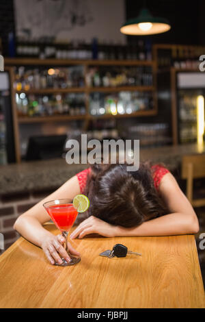 Drunk woman driver leaning on counter with her cocktail Stock Photo