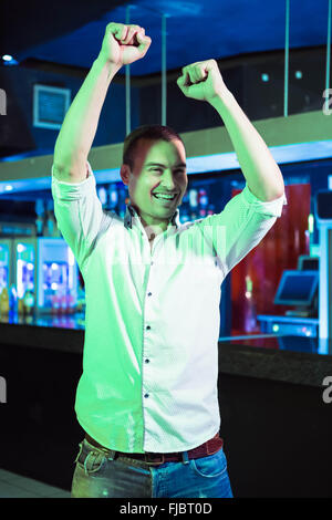 Happy man dancing in front of bar counter Stock Photo