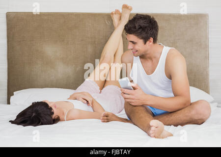 Couple talking to each other while relaxing on bed Stock Photo
