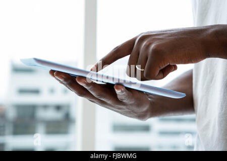 Man using digital tablet near window Stock Photo