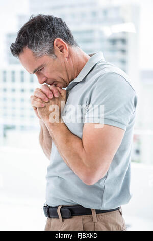 Tensed man standing against window Stock Photo