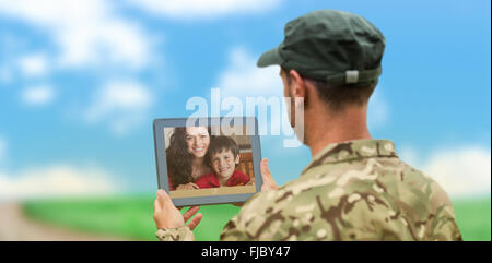 Composite image of soldier using tablet pc Stock Photo