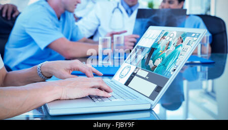 Composite image of doctor typing on keyboard with her team behind Stock Photo