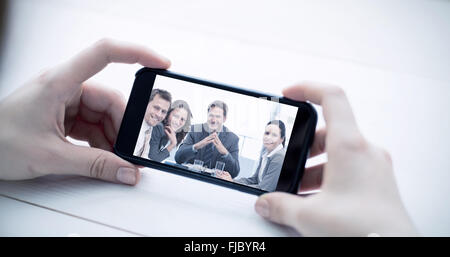 Composite image of cropped image of man holding smartphone Stock Photo