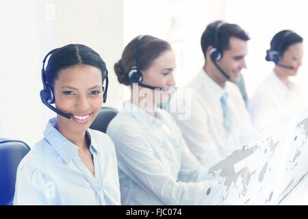 Composite image of business people with headsets using computers Stock Photo