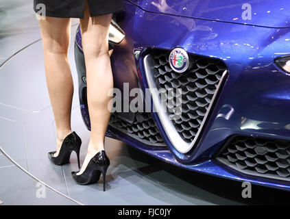 Geneva, Switzerland. 1st Mar, 2016. A woman walking by an Alfa Romeo Giulia during the first press day of the Geneva International Motor Show, in Geneva, Switzerland, 1 March 2016. The motor show will be open to the public from 03 to 13 March 2016. Photo: ULI DECK/dpa/Alamy Live News Stock Photo