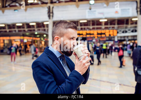 Hipster businessman drinking coffee at the train station Stock Photo