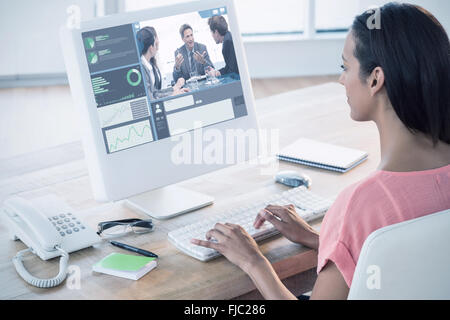 Composite image of businesswoman using computer at desk in creative office Stock Photo