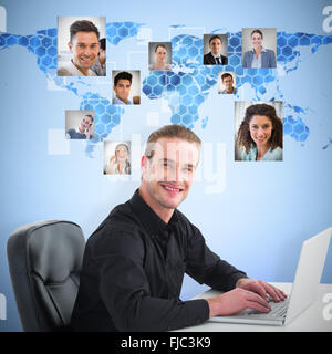 Composite image of smiling businessman using laptop at desk Stock Photo