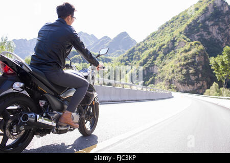 Young Chinese man riding motorcycle Stock Photo