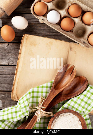 Blank vintage recipe cooking book, utensils and ingredients on wooden table. Top view with copy space Stock Photo