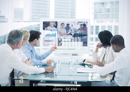 Composite image of editor holding tablet and smiling as team works behind her Stock Photo