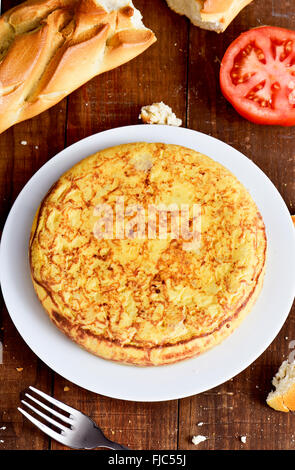 closeup of a plate with a typical tortilla de patatas, a spanish omelet, on a dark wooden table Stock Photo