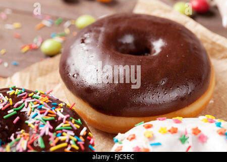 Donuts and candies on wooden table Stock Photo