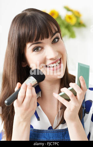 Young Woman Putting On Make Up At Home Stock Photo