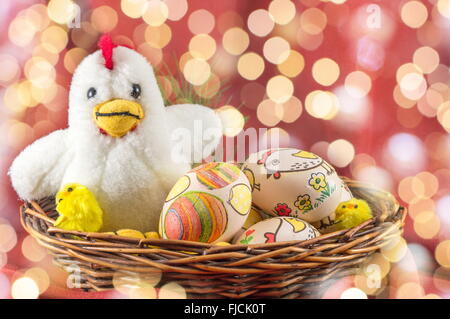 Decoupage decorated Easter eggs and family of toy chickens in a nest Stock Photo